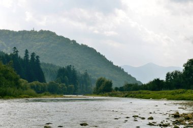 Dağlar ve gökyüzü arka plan üzerinde kayalık dağ Nehri