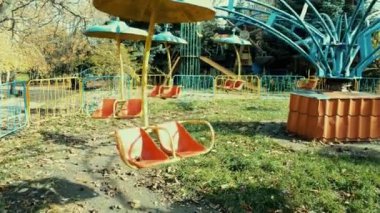 Eski bir terk edilmiş atlıkarınca parkta güneş ışığına çıkıyor.