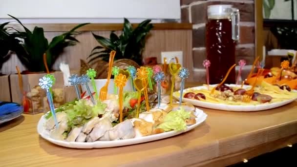 Canapés de carne com espetos coloridos em um prato na mesa do buffet — Vídeo de Stock