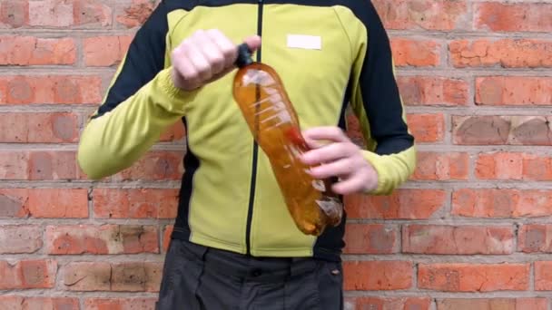 Человек Зеленой Рубашке Уменьшает Коричневую Пластиковую Бутылку Выпускает Воздух Перед — стоковое видео