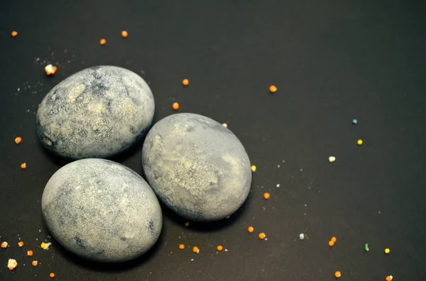 Три яйца, окрашенные чай гибискус на черном фоне, в крошки сахарной глазури, как яйцо дракона с копипространством — стоковое фото