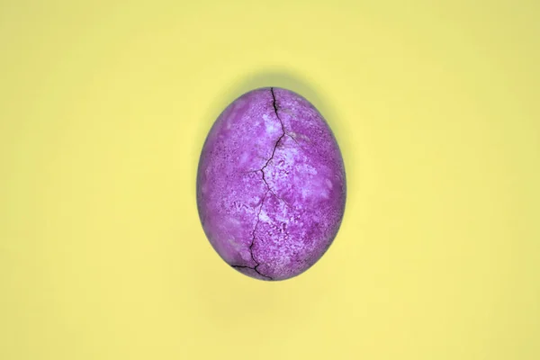 Çatlak ile Mor yumurta, çay ebegümeci boyalı, sarı arka plan üzerinde, copyspace ile gezegen ve mermer benzer