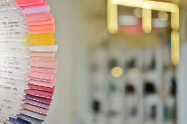 Bulanık ampuller ve aynalar bir arka plan karşı, koyu pembe jel cila renk örnekleri ile Palet