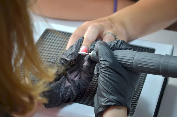Manicurist in zwarte handschoenen verwijdert gel Polish met een router, Top View — Stockfoto