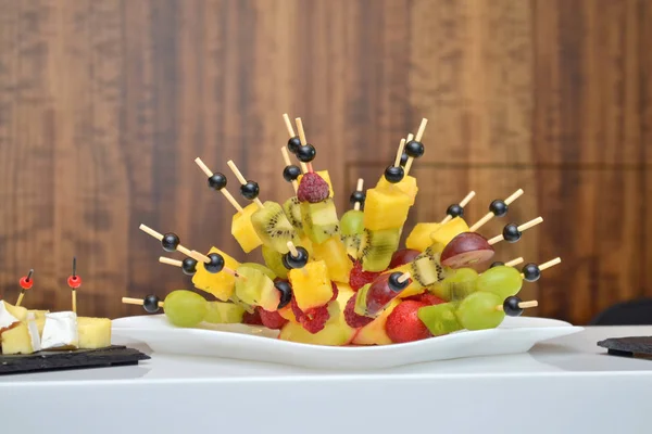 Ovocné závěsy ve formě Ježek na hostině na stole na dřevěném pozadí — Stock fotografie