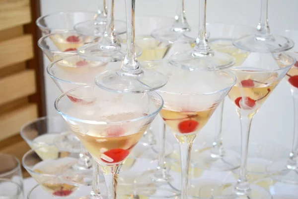 Trojúhelníková sklenka na Martini, plná šampaňského s třešně a tekutým dusíkem, vytvářející páru, tvar pyramidy — Stock fotografie