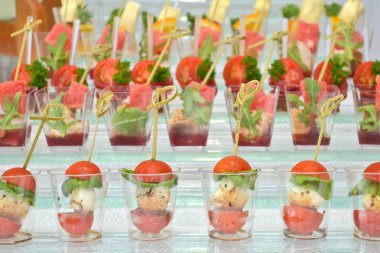 Bir ziyafette cam adım desteği şeffaf gözlük ve ahşap şişler kanepeler farklı türleri