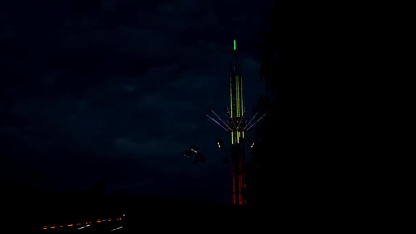 Carrousel d'attraction sur un long fond, multicolore avec des ampoules dans la nuit — Video