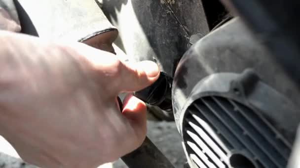 Při kontrole hladiny motorového oleje na motorce se muž odšroubování ventilu — Stock video