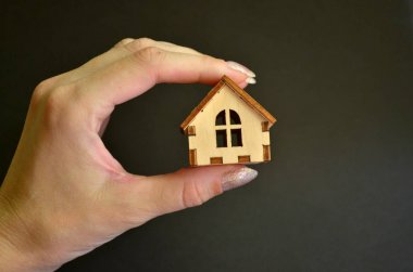 Siyah arka plan ön görünümde kadın elinde ahşap oyuncak ev, copyspace ile