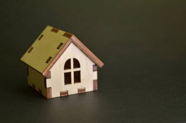 Copyspace ile siyah bir arka plan üzerinde ahşap oyuncak ev modeli