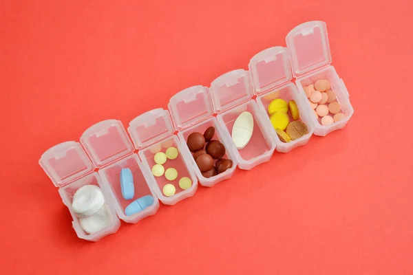 Pills için Plastik günlük organizatör, copyspace ile mercan arka plan üzerinde farklı hapları ile kutu, üst görünümü — Stok fotoğraf