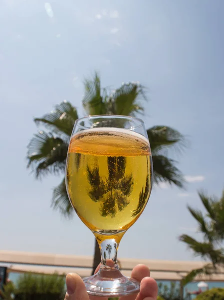 A glass of cold beer close-up against a blue sky