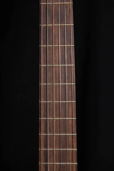 Acoustic guitar over black background standing position