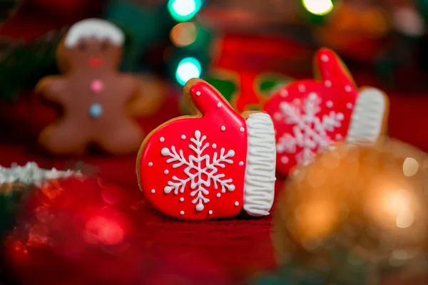 Gingerbread cookies in the form of red gloves on a red Christmas background. Became a LIKE.