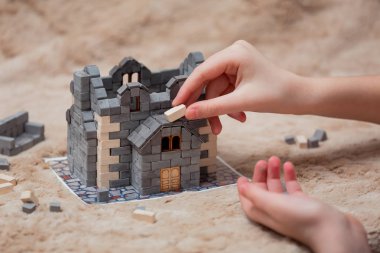 Çocukların elleri tuğladan bir evin modelini yapar. Yaratıcılık için yapıcı.