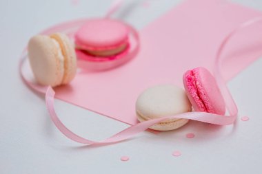 Pembe ve beyaz makaron ve pembe dekor ile beyaz arka plan.