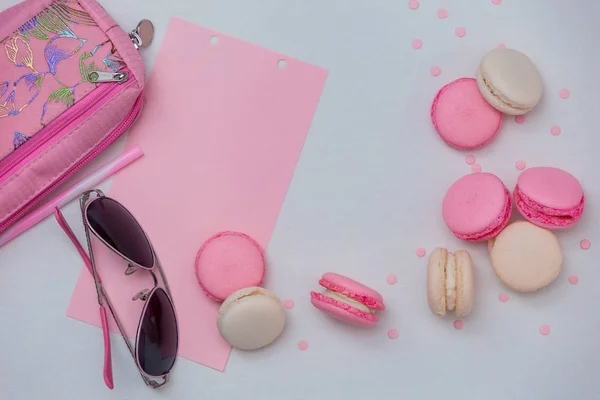 Pembe ve beyaz macaroons ile beyaz arka plan, pembe gözlük ve kalem kılıfı, Pink dekor ile.