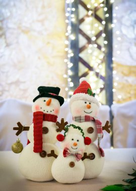 Çelenklerin arka planında kardan adam şeklinde yeni yıl süslemeleri iç mekanı süslüyor..