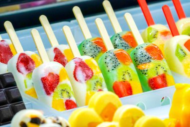 Gözlük düzenlenmiş meyveli; Kivi, çilek, berry, dragon meyve, papaya, mango, nane, çikolata, süt, portakal, ananas dondurma sopa, donmuş makinesinde dondurulmuş.