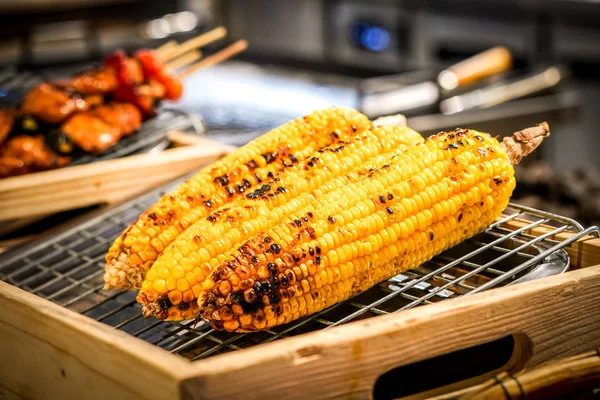 焼きトウモロコシとグリルのぼかしの横にバーベキュー — ストック写真