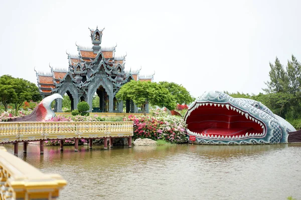 gri duvar ve turuncu bir çatı havuzu, büyük balık heykelinin etrafında, Tayland inanç hikaye ile ortasında Pavyonu.
