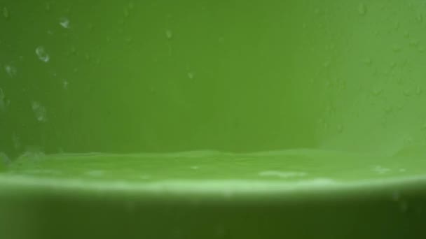 雨水滴と下部に緑色のプラスチックでスプラッシュ — ストック動画