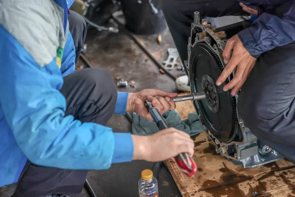 2 mechanic men try to fix and setup boat engine.