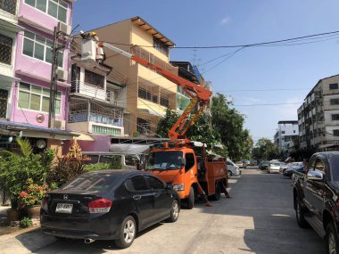 POM Prap Sattru Phai bölgesi, Bangkok, Tayland - 19 Mart 2018: elektrikçi kamyon vinç üzerinde kaymıştır denetleme ve onarma ana elektrik güç hattı Soi Mansri alan, Pomprab, Bangkok, Tayland.
