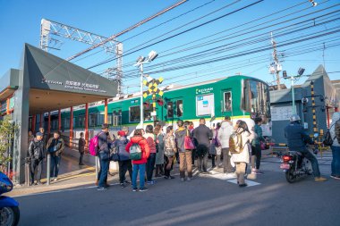 Kyoto, Japonya - 2 Mar 2018: Fushimi Inari tapınak Kyoto, Japonya 2 Mar 2018 üzerinde giderken yolun karşısında tren yerel Japon ve turist bekliyor.