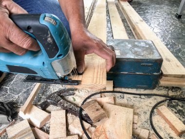 Marangoz ahşap testere ile ahşap duvar ve Dekorasyon, müşterinin evde sitede çalıştı yaptığı hizmet için oluşturun.