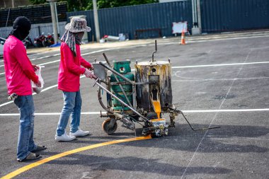 İşçiler üzerinde asfalt roat termoplastik boya ile makine tarafından astar
