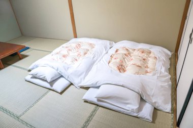 Futon; a Japanese quilted mattress rolled out on the floor (tatami) for use as a bed., Japan style. clipart