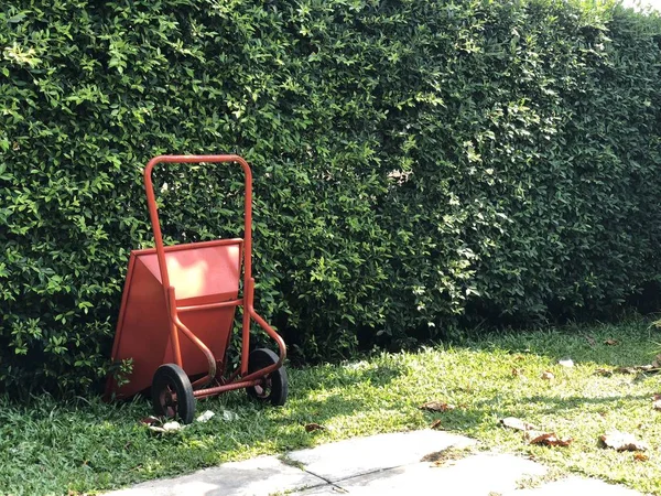 red new Masonry cement cart trolley parking in the garden with tree background. Vintage style.