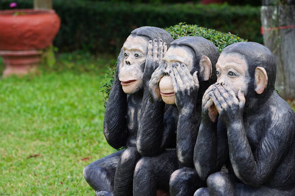 three black monkeys statue siting on the rock in the row; close eyes, close mouth, close ear., Thailand