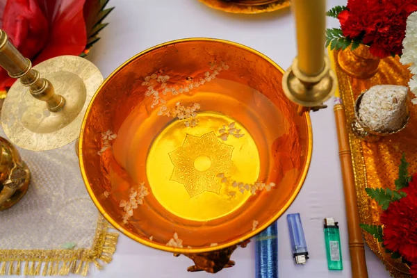 Holy water with melted candle in gold  pan, Thai Buddhist traditional ceremony at north of Thailand.