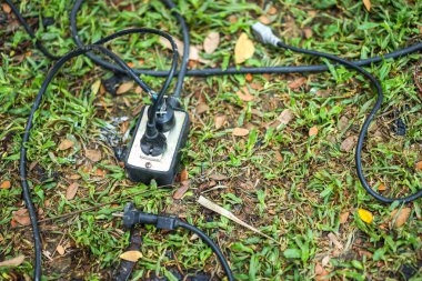 soket, Tak ve bahçedeki çimlerin üzerine elektrik siyah kablo.