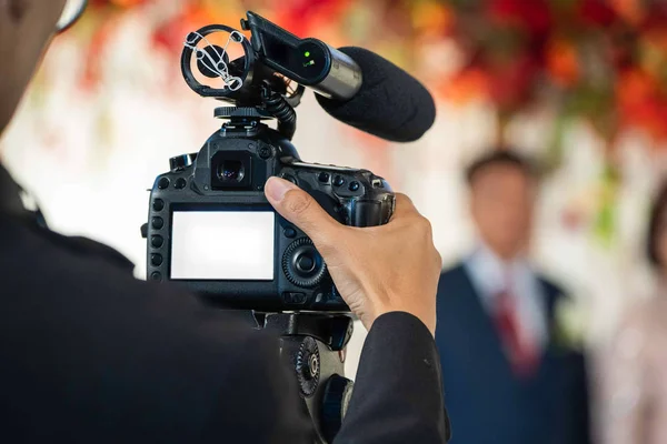在后台的女摄影师在婚礼活动中拍摄和录制视频 — 图库照片
