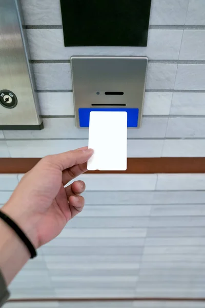 securing lift or elevator access control, man\'s hand is holding a key card lay up to insert in card hold for unlocking elevator doors before up or down.