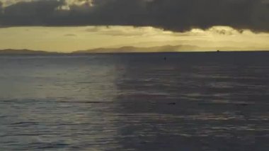 Karanlık ekrana yatay deniz kenarına düşen gökyüzünde kalp şekli gibi Timelapse Sunset ışık.