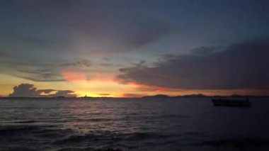 Karanlık ekrana yatay deniz kenarına düşen gökyüzünde kalp şekli gibi Timelapse Sunset ışık.