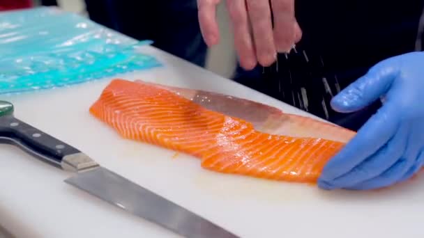 Koch Gibt Salz Dazu Und Schneidet Frischen Rohen Lachs Auf — Stockvideo