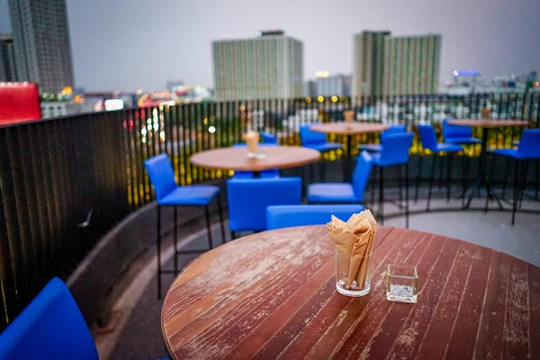 Rooftop dinner table with napkin and ashtray on it.