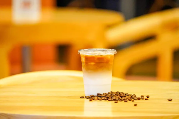 나무 테이블에 커피 콩과 라떼를 가져 가라. — 스톡 사진