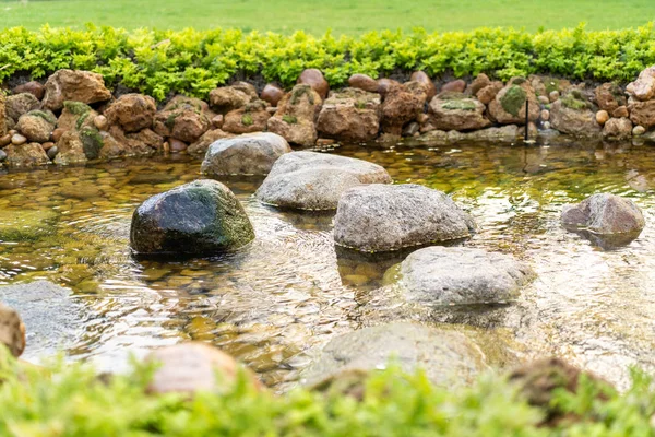 Kő a kis gőzölgő folyó által létrehozott ember a kertben — Stock Fotó