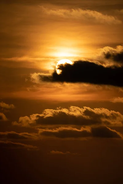 Feche o sol com a nuvem à sua frente ao pôr-do-sol — Fotografia de Stock