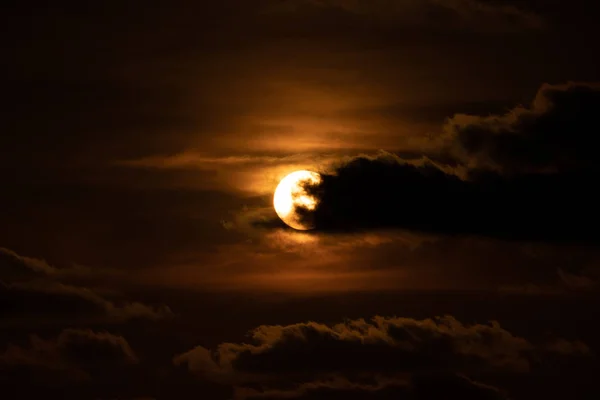 夕焼けの夕暮れ時に目の前に雲が立ち込んで太陽を閉じる — ストック写真
