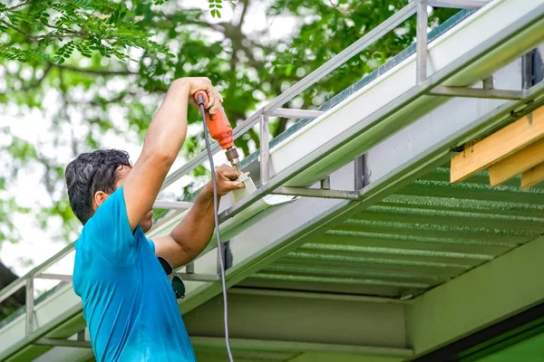 Azjatycki pracownik Śruba, śrubokręt do tworzenia i naprawy rooftopa — Zdjęcie stockowe