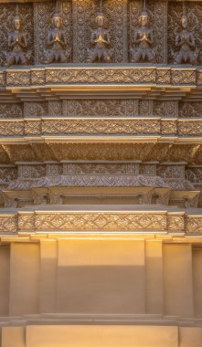 Altın sarısı küçük Tayland Tanrısı sıcak ışıkla altın kare direğin üzerinde