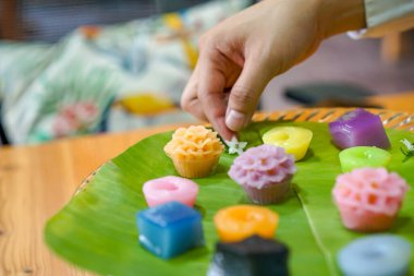 Tayland Şefi 'nin eli çeşitli dekore ediyor geleneksel renkli Tayland tatlıları; buharda pişmiş un, kara muhallebi, hindistan cevizi kreması ve buharda pişmiş fasulye, katmanlı puding